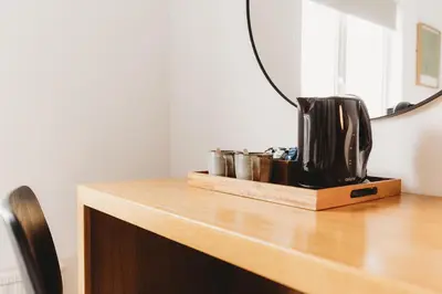 a coffee maker on a wooden counter with a mirror at Hotel VARA in Truro