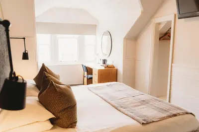 a bedroom with a bed and a desk with a mirror at Hotel VARA in Truro