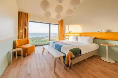 a bedroom with a bed with a view of the ocean at SeaSpace in Newquay