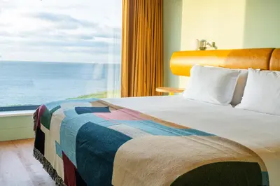 a bedroom with a bed with a view of the ocean at SeaSpace in Newquay