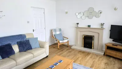 a living room with a couch and a fireplace at Fairlee in Perranporth