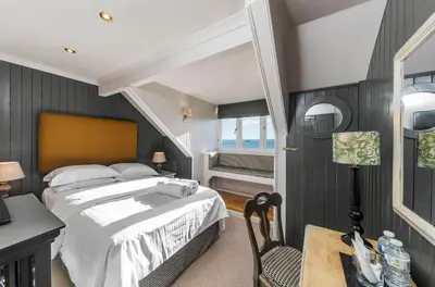 a bedroom with a bed and a table and a chair at Bosanneth in Falmouth