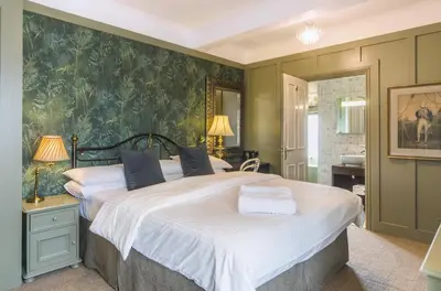 a bedroom with a large bed and a bathroom at Bosanneth in Falmouth