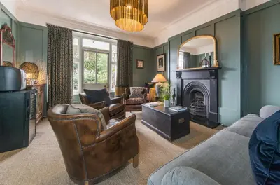 a living room with a couch and chairs and a fireplace at Bosanneth in Falmouth