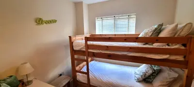 two bunk beds in a room with a window at Sand Dunes in Perranporth