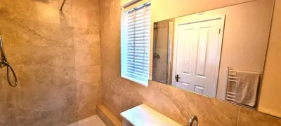 a bathroom with a sink and a mirror and a window at Sand Dunes in Perranporth
