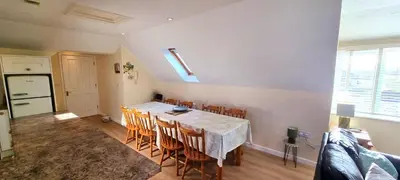 a kitchen and dining room with a table and chairs at Sand Dunes in Perranporth
