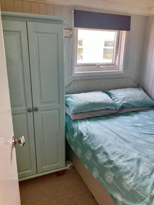 a small bedroom with a bed and a window at Pensilva in Hayle
