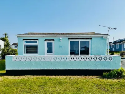 a blue house with a white fence in front of it at Pensilva in Hayle