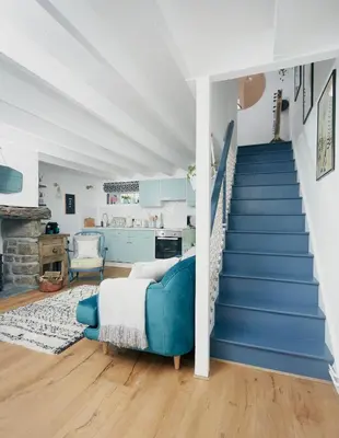 a bedroom with blue stairs and a blue couch at Poachers Pocket Cottage in Bodmin