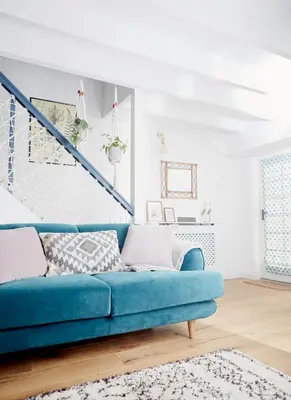 a blue couch in a living room with a staircase at Poachers Pocket Cottage in Bodmin