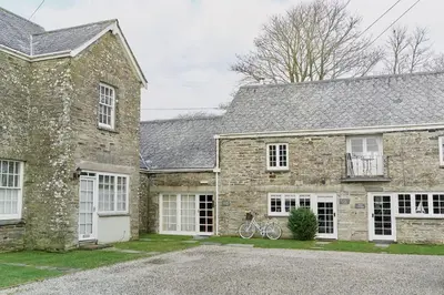 a brick house with a bike parked in front of it at Poachers Pocket Cottage in Bodmin