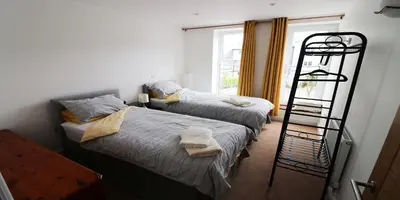 a bedroom with two beds and a ladder next to a window at Yachtsmans Rest in Falmouth