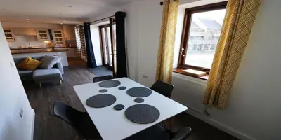 a table and chairs in a room with a window at Yachtsmans Rest in Falmouth