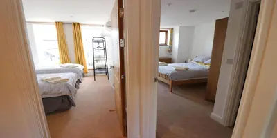 a room with two beds and a room with a window at Yachtsmans Rest in Falmouth