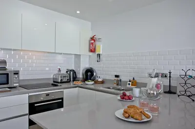 a white kitchen with two plates of food on a counter at 5 Fistral Beach, Newquay in Newquay