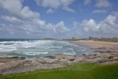 a beach with rocks and the ocean on a cloudy day at 5 Fistral Beach, Newquay in Newquay
