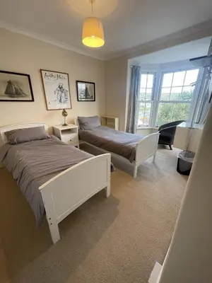 a bedroom with two beds and a window at Michaelstow in Perranporth