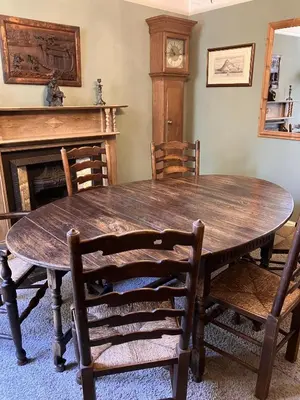 a wooden table and chairs in a room with a fireplace at Michaelstow in Perranporth