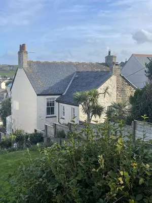 a white house with a black roof at Michaelstow in Perranporth