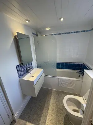 a bathroom with a sink and a toilet and a tub at Michaelstow in Perranporth