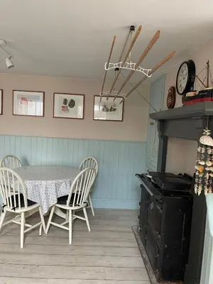 a dining room with a table and chairs and a clock at Michaelstow in Perranporth