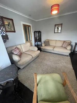 a living room with two couches and a table at Michaelstow in Perranporth