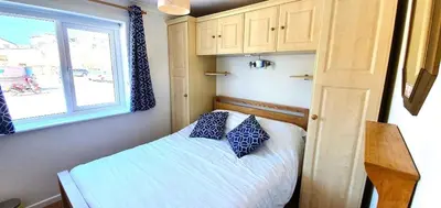 a small bedroom with a bed and a window at 7 Penhale in Perranporth
