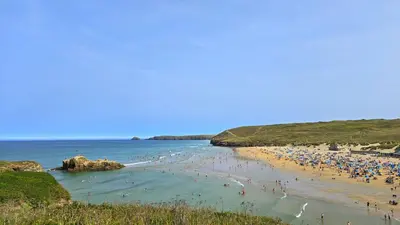 a group of people on a beach with the ocean at 7 Penhale in Perranporth
