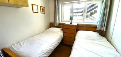 two beds in a small room with a window at 7 Penhale in Perranporth
