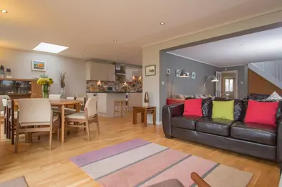 a living room with a couch and a dining room at Warwick Lodge in Perranporth