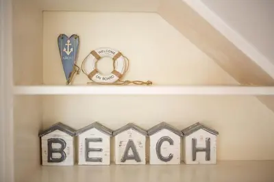 a shelf with a beach sign and a peace sign at Warwick Lodge in Perranporth