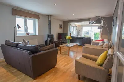 a living room with two couches and a living room with at Warwick Lodge in Perranporth