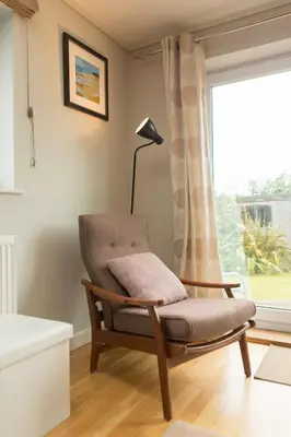 a chair in a living room with a window at Warwick Lodge in Perranporth