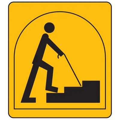 a yellow sign of a man walking up stairs with a shovel at King Arthurs Arms in Tintagel