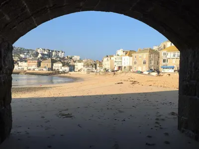 a view of a beach from a stone archway at Talland Studio in St Ives