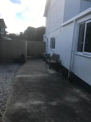 a patio with two benches next to a building at Talland Studio in St Ives