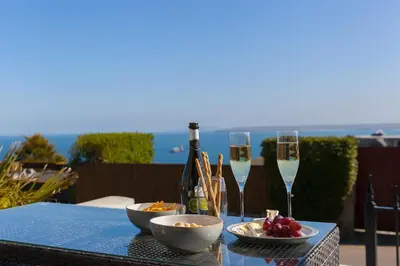 a table with two glasses of champagne and a bowl of fruit at Sea Scapes in St Ives
