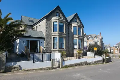 a large house with a fence in front of it at Sea Scapes in St Ives