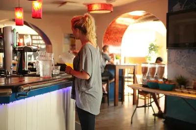 a woman standing at a counter in a kitchen at St Christopher's Inn Newquay in Newquay
