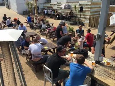 a group of people sitting on benches at tables at St Christopher's Inn Newquay in Newquay