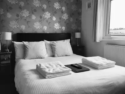 a bedroom with a bed with two towels on it at Tregorran Guest House Mevagissey in Mevagissey