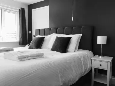 a black and white bedroom with a large bed at Tregorran Guest House Mevagissey in Mevagissey