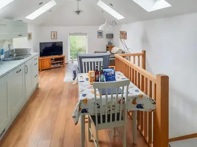 a kitchen and dining room with a table and chairs at Ladyvale Barn in Cardinham