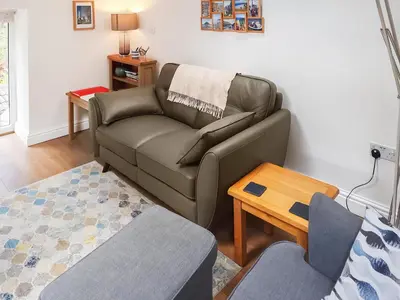 a living room with a couch and a table at Ladyvale Barn in Cardinham