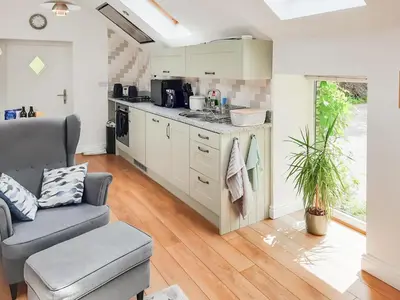 a kitchen with a couch and a chair in a room at Ladyvale Barn in Cardinham