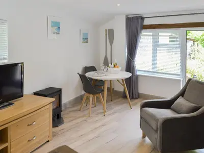 a living room with a table and a tv at The Nest in Uny Lelant