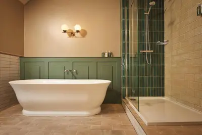 a bathroom with a tub and a glass shower at The Rising Sun in Saint Mawes