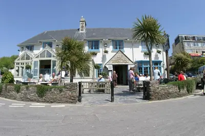 a group of people sitting outside of a building at The Rising Sun in Saint Mawes