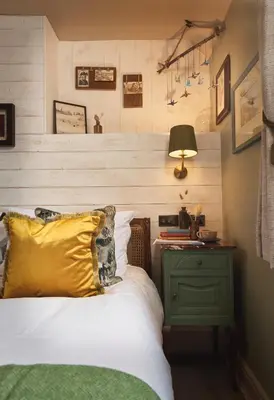 a bed with a yellow pillow and a green night stand at The Rising Sun in Saint Mawes